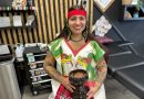 Local tattoo artist holds wears ceremonial dress and holds vessel for burning cleansing items.